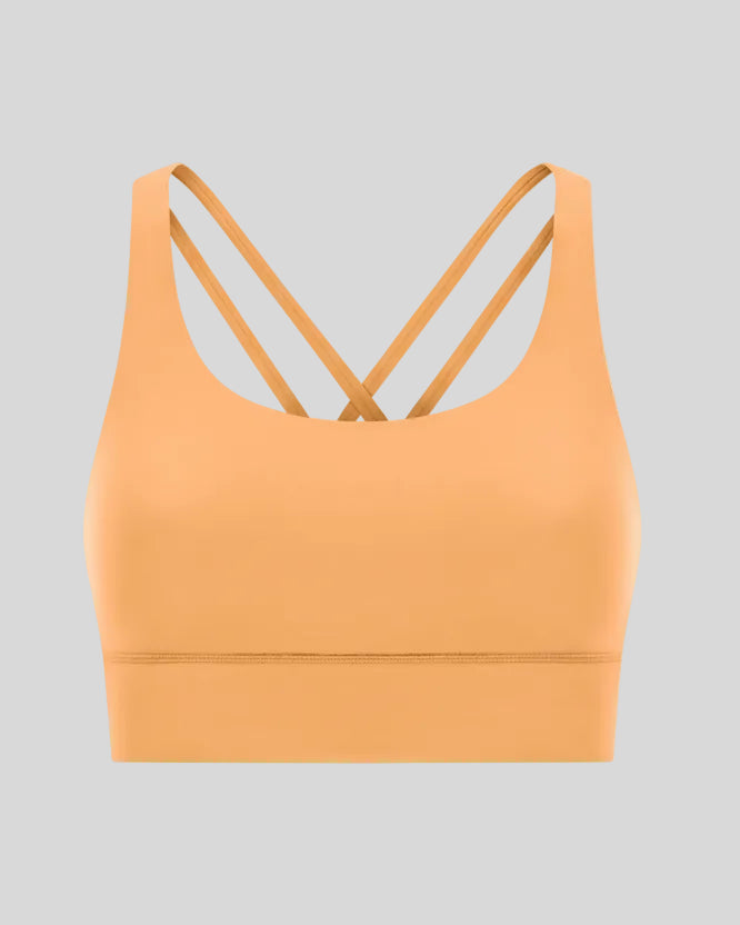 3D product view of the AlignCross Studio Bra in gold, highlighting the scoop neckline and crisscross back straps.