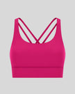 3D product view of the AlignCross Studio Bra in hot pink, highlighting the scoop neckline and crisscross back straps.