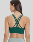 Back view of the AlignCross Studio Bra in dark green, highlighting the crisscross strap design.