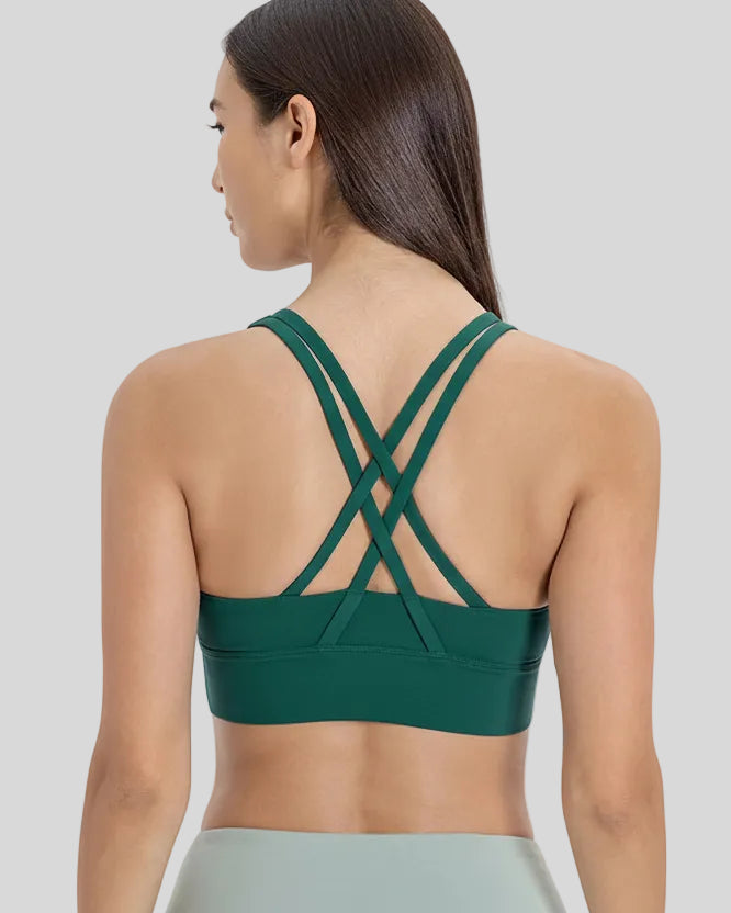 Back view of the AlignCross Studio Bra in dark green, highlighting the crisscross strap design.