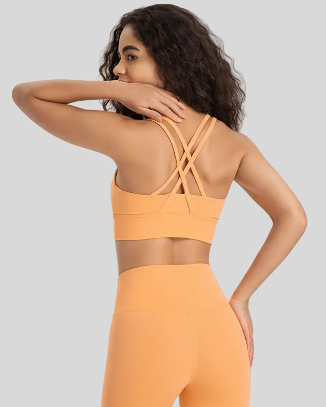 Back view of the AlignCross Studio Bra in gold, highlighting the crisscross strap design.