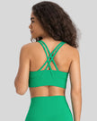 Back view of the AlignCross Studio Bra in green, highlighting the crisscross strap design.