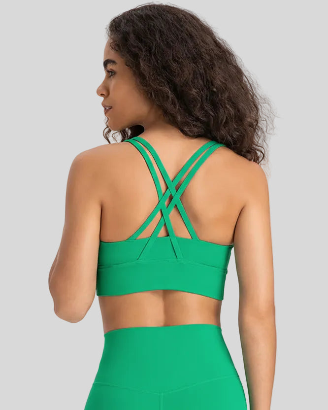 Back view of the AlignCross Studio Bra in green, highlighting the crisscross strap design.