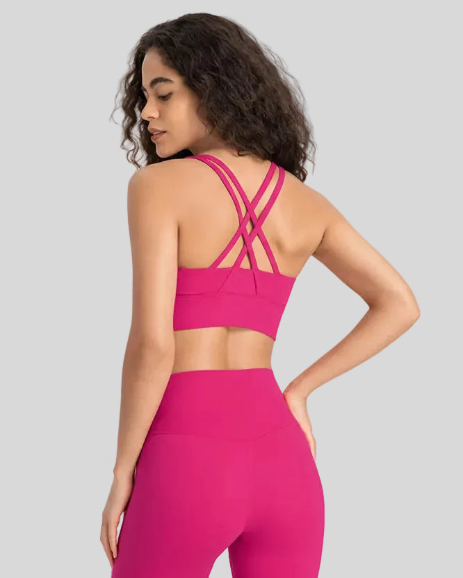 Back view of the AlignCross Studio Bra in hot pink, highlighting the crisscross strap design.