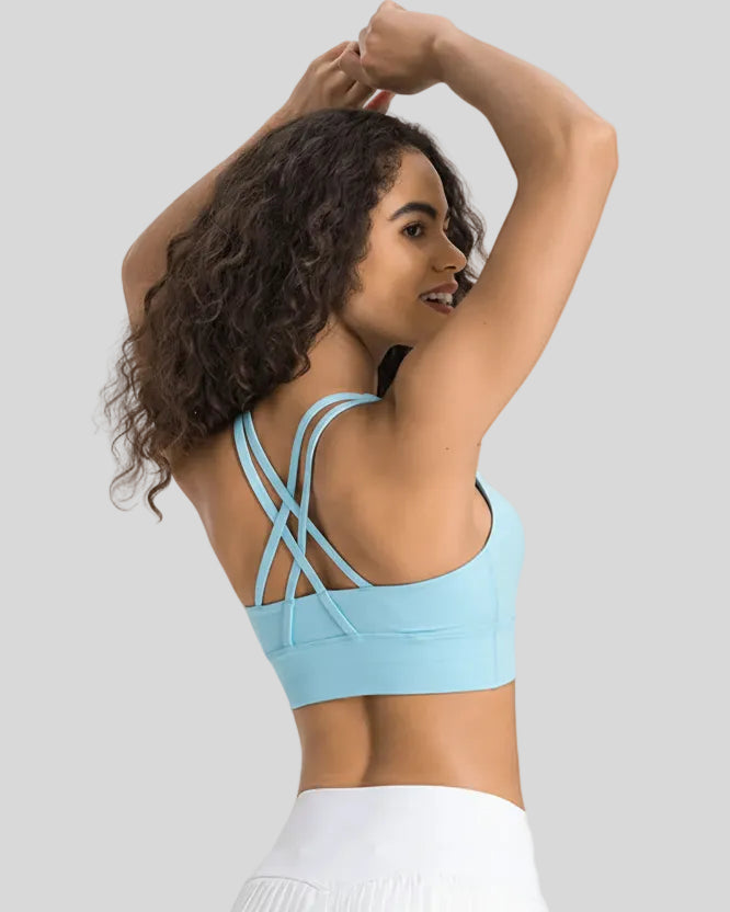 Back view of the AlignCross Studio Bra in pastel blue, highlighting the crisscross strap design.