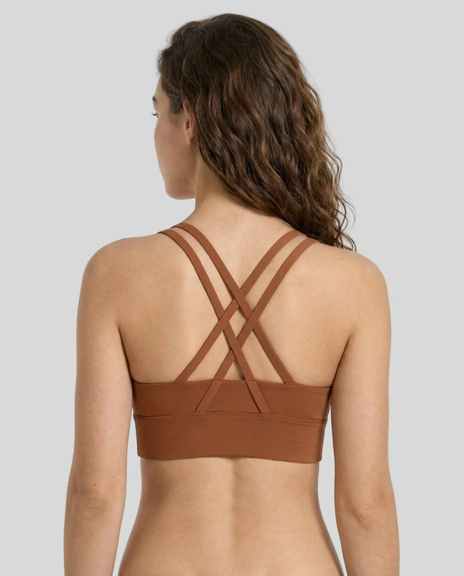 Back view close up of model a caramel AlignCross Studio Sports Bra sports bra highlighting crisscross straps design