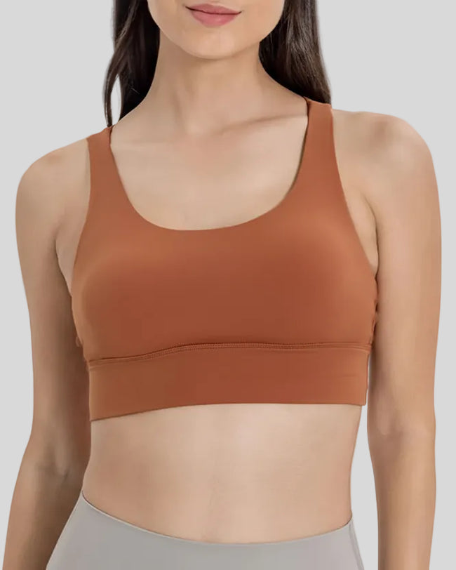 AlignCross Studio Bra in caramel brown worn by model, featuring a scoop neckline and soft supportive fit.