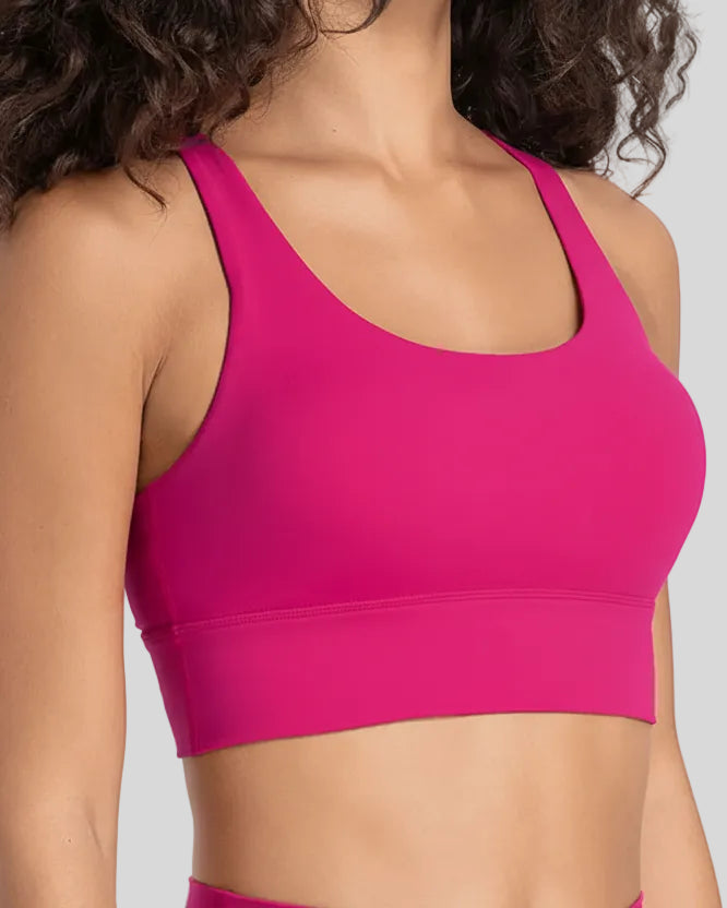 AlignCross Studio Bra in hot pink worn by model, featuring a scoop neckline and soft supportive fit.