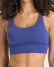 AlignCross Studio Bra in royal blue worn by model, featuring a scoop neckline and soft supportive fit.