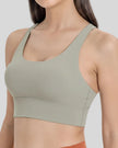 AlignCross Studio Bra in sage worn by model, featuring a scoop neckline and soft supportive fit.