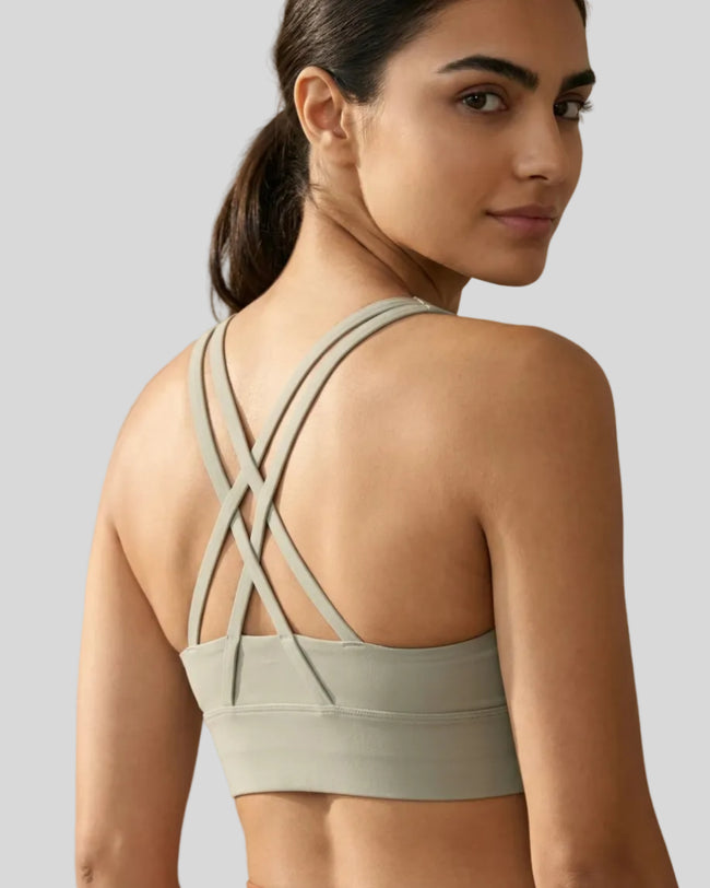 Back view close up of model a sage AlignCross Studio Sports Bra sports bra highlighting crisscross straps design