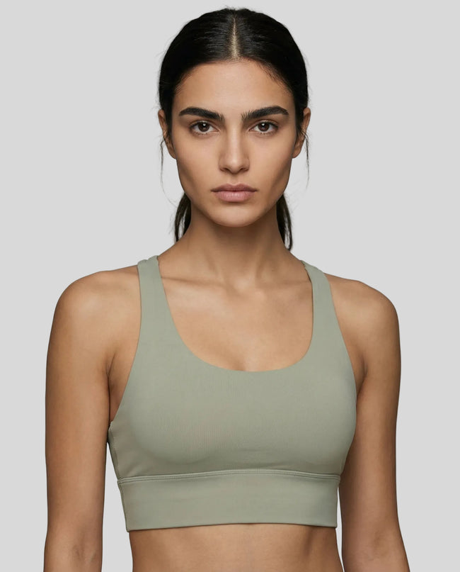 Model wearing a sage AlignCross Studio Sports Bra highlithing neck and waistline