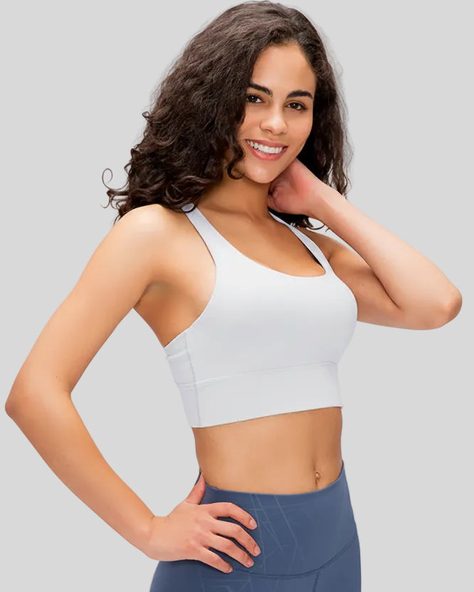 Side view of the AlignCross Studio Bra in white, highlighting the crisscross strap design.