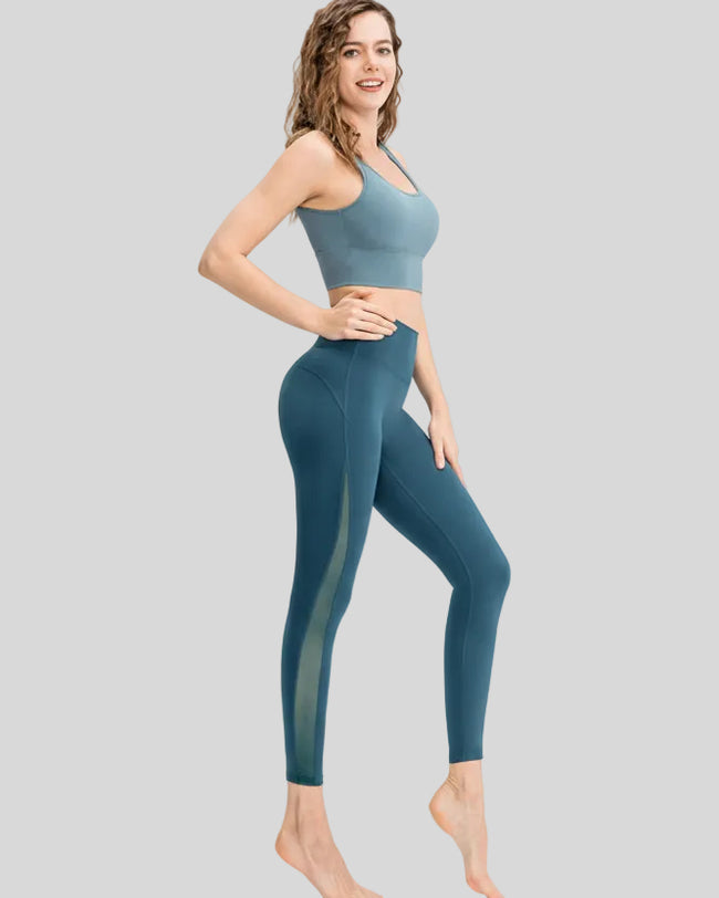 Full body side angle view of AeroFlow mesh legging in deep teal with breathable side panels