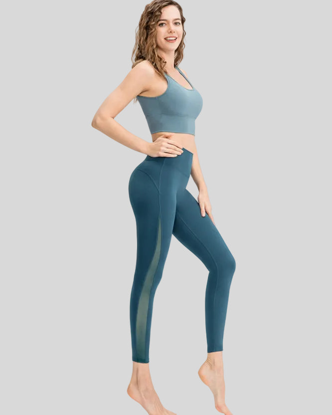 Full body side angle view of AeroFlow mesh legging in deep teal with breathable side panels