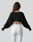 Back view of AirLoom Knit Shrug in black with oversized sleeves and cropped silhouette