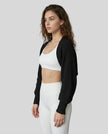 Side view of model wearing AirLoom Knit Shrug in black
