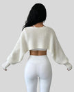 Back view of AirLoom Knit Shrug in white with oversized sleeves and cropped silhouette