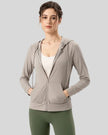 Tan active hoodie worn with half zip down, front view