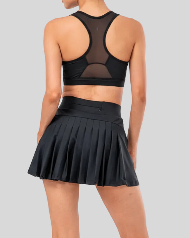 Back view of high-rise pleated active skirt in black with built-in shorts