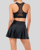 Back view of high-rise pleated active skirt in black with built-in shorts