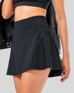 Side view of pleated active skirt in black highlighting lightweight drape and athletic fit