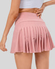 Back view of high-rise pleated active skirt in blush pink with built-in shorts