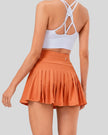 Back view of high-rise pleated active skirt in caramel with built-in shorts