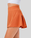 Side view of pleated active skirt in caramel highlighting lightweight drape and athletic fit