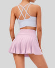Back view of high-rise pleated active skirt in pink purple with built-in shorts