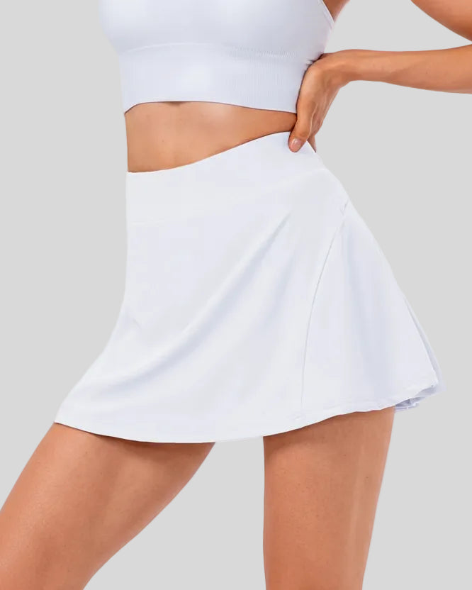 Front angle view of high-rise pleated active skirt in white with smooth waistband and lightweight performance fabric