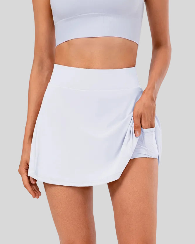 Front left angle view of built-in shorts and pocket detail on pleated active skirt in white