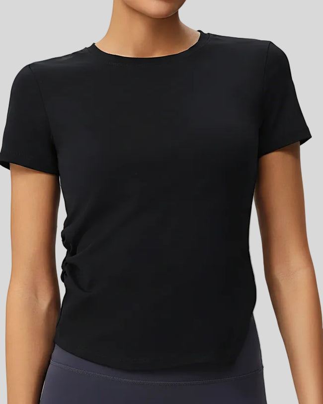 AsymFlow short sleeve active top in black with relaxed fit and round neckline