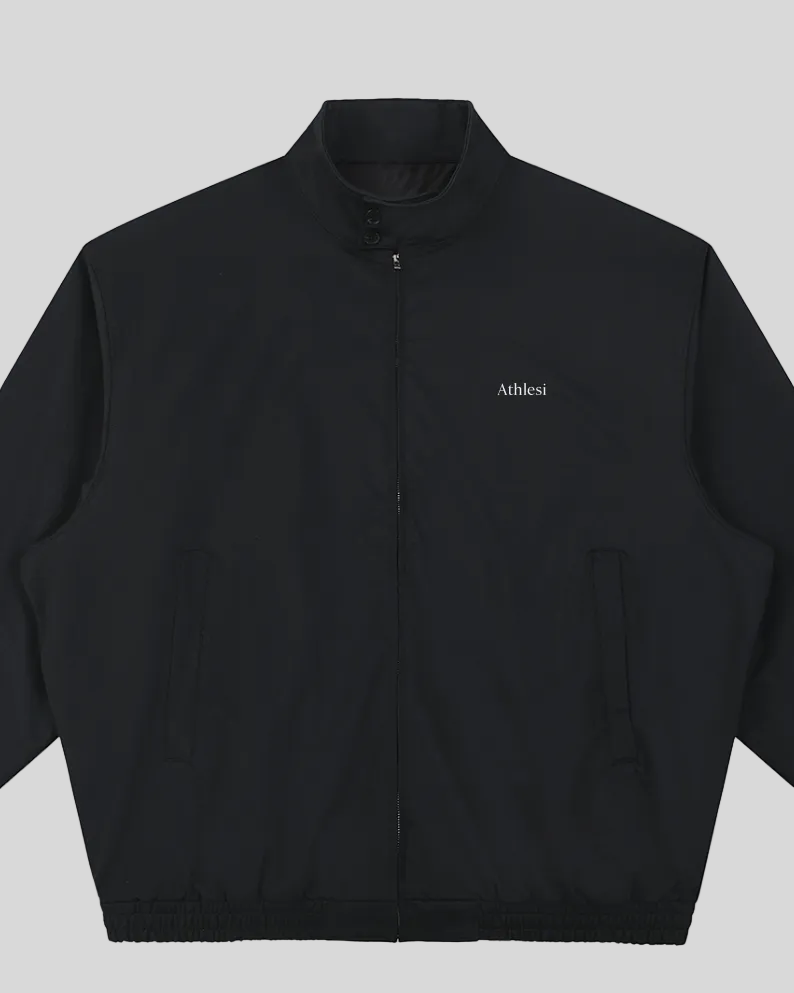 Closeup of stand collar, Athlesi logo, button detail and front zipper on Axis Bomber Jacket in Black