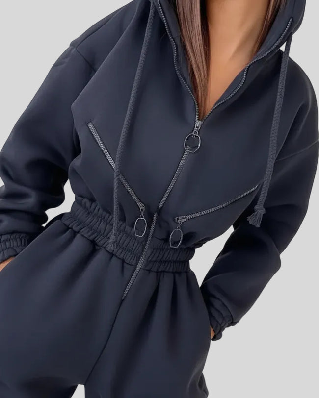Closeup of zip hoodie and elastic waist detail on Athlesi Balance Zip Jumpsuit in gray