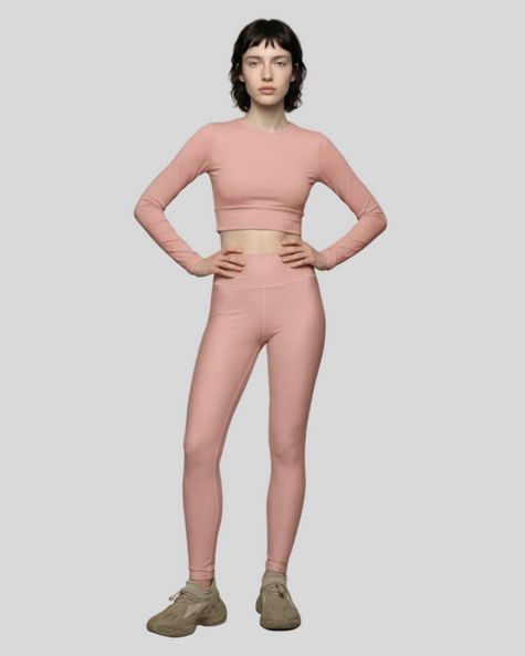 Front view of woman wearing a Athlesi Blush Form activewear outfit in soft blush on a light gray background