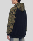 Upper body back angle view of man wearing Camo Accent Hoodie in black with green camo sleeves