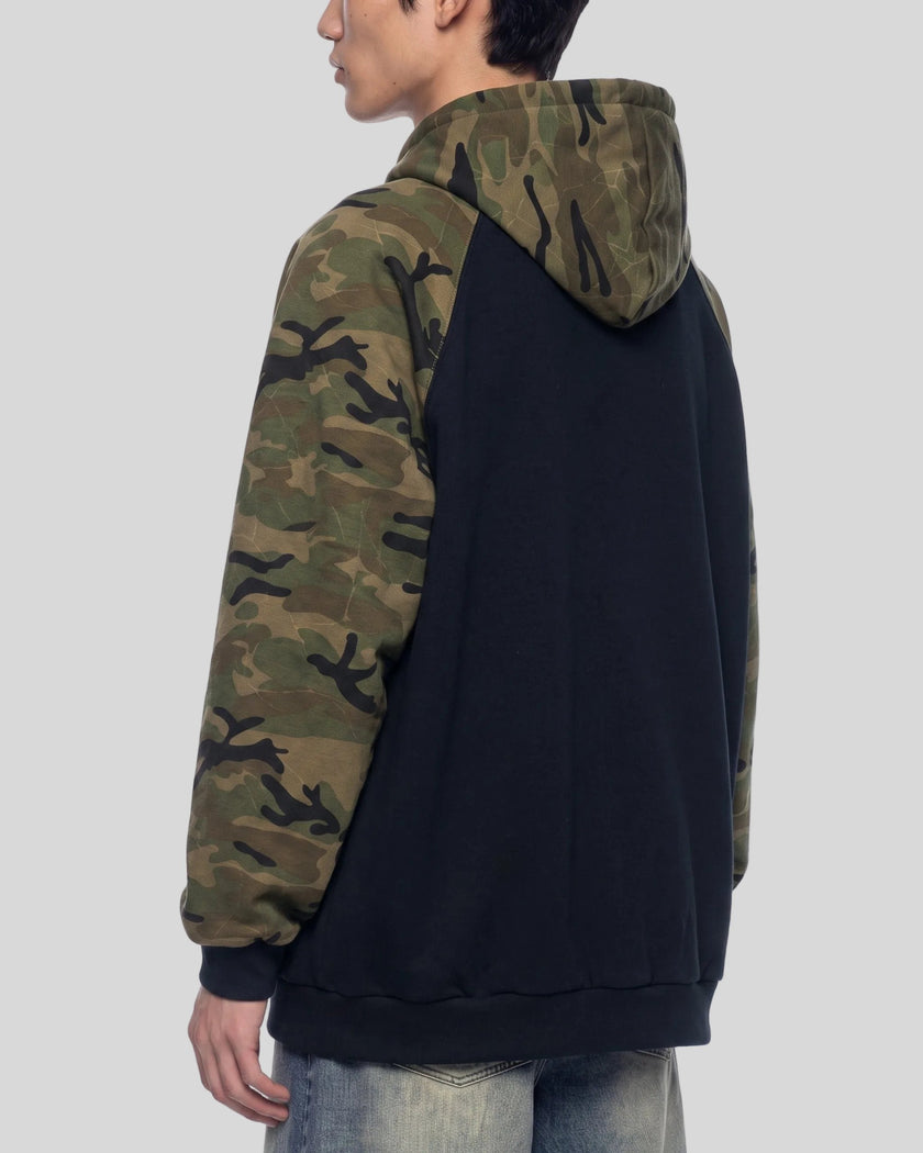 Upper body back angle view of man wearing Camo Accent Hoodie in black with green camo sleeves