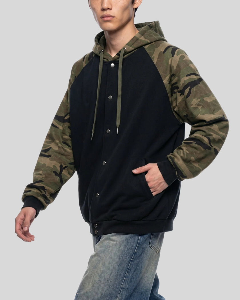 Upper body front angle view of man wearing Camo Accent Hoodie in black with pockets and green camo sleeves