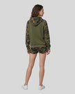 Full body back view of woman wearing Camo Accent Hoodie in army green with green camo hood and sleeves