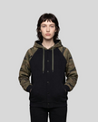 Mid body front view of woman wearing Camo Accent Hoodie in black with green camo sleeves