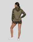 Full body back view of woman wearing Camo Accent Hoodie in khaki with green camo hood and sleeves