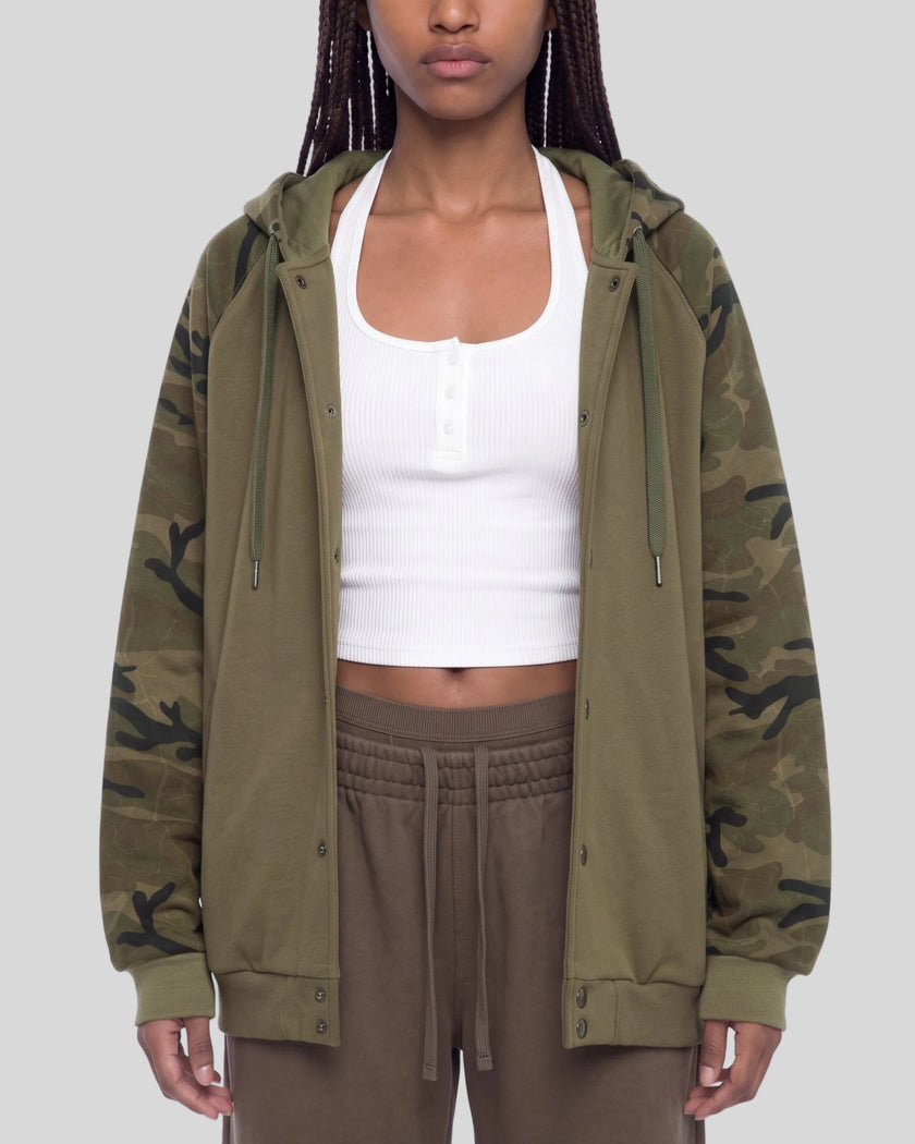 Upper body front view of woman wearing Camo Accent Hoodie in khaki with green camo sleeves