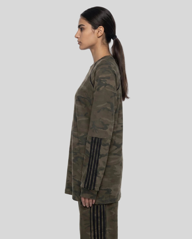 Mid body side view of woman wearing Camo Accent Long Sleeve Tee with striped sleeve detail