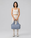 Model carrying CarryForm Studio Bag in dusty blue styled for gym and everyday use