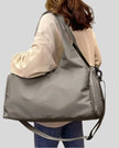 Side angle of model carrying CarryForm Studio Bag in dusty pink styled for gym and everyday use