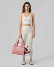 Model carrying CarryForm Studio Bag in dusty pink styled for gym and everyday use