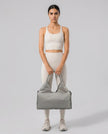 Model carrying CarryForm Studio Bag in gray styled for gym and everyday use