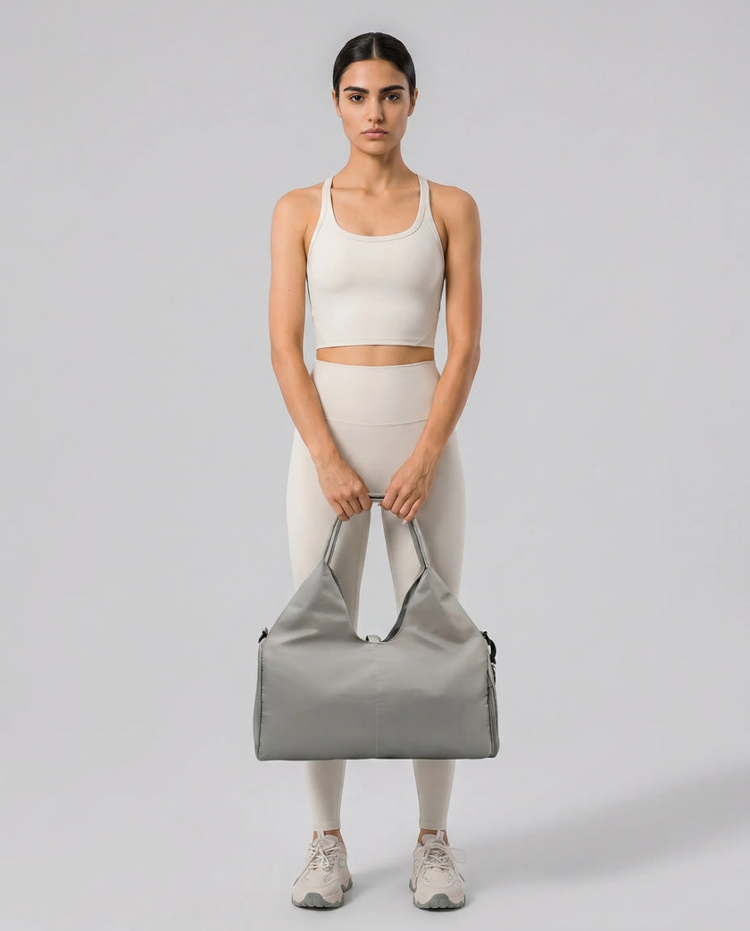 Model carrying CarryForm Studio Bag in gray styled for gym and everyday use