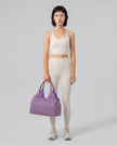 Model carrying CarryForm Studio Bag in red violet styled for gym and everyday use